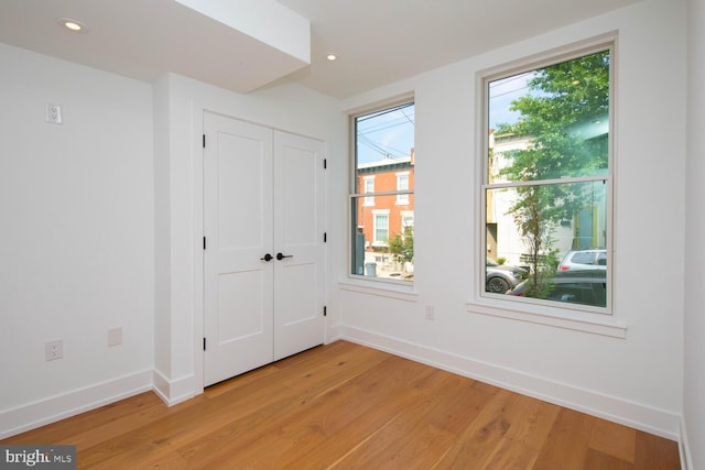 spare room with a healthy amount of sunlight and light hardwood / wood-style floors