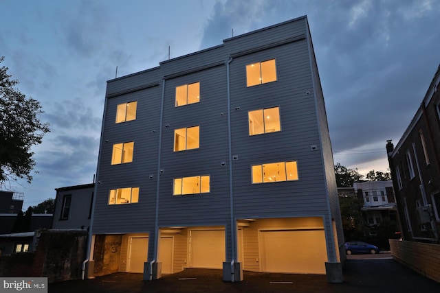 back house at dusk with a garage