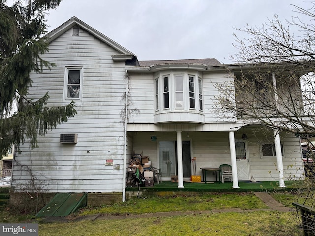 rear view of property featuring a lawn