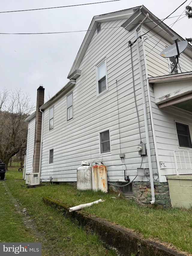 view of side of property with a lawn and central air condition unit