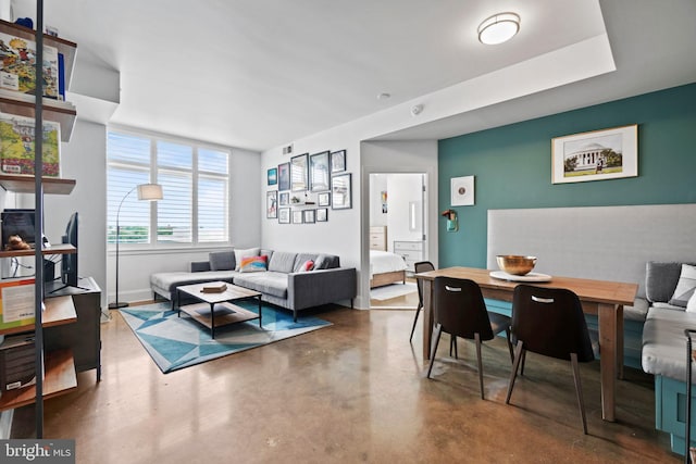 living room featuring baseboards, visible vents, and concrete flooring