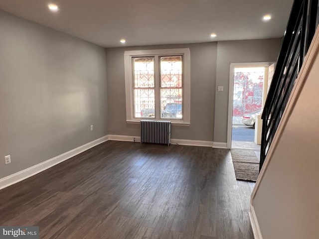 unfurnished room featuring dark hardwood / wood-style flooring and radiator