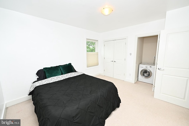 carpeted bedroom with a closet and washer / dryer