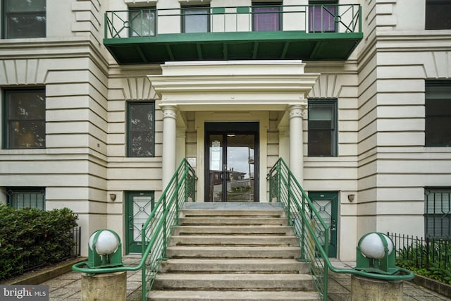 view of exterior entry with a balcony