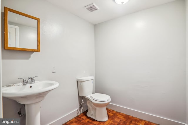 bathroom with parquet floors and toilet