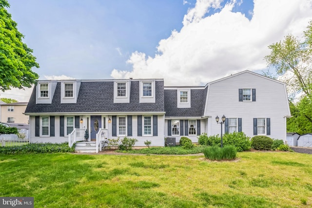 cape cod house with central AC unit and a front lawn