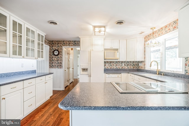 kitchen with decorative light fixtures, white appliances, dark wood-type flooring, white cabinets, and sink