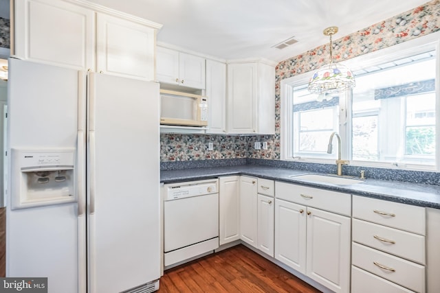 kitchen with pendant lighting, white appliances, white cabinetry, sink, and hardwood / wood-style flooring