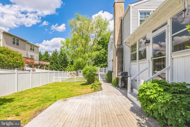 wooden deck with area for grilling and a lawn