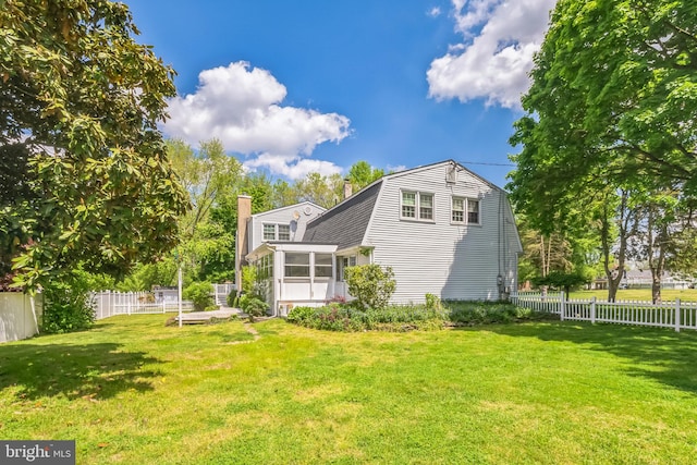 rear view of house featuring a yard