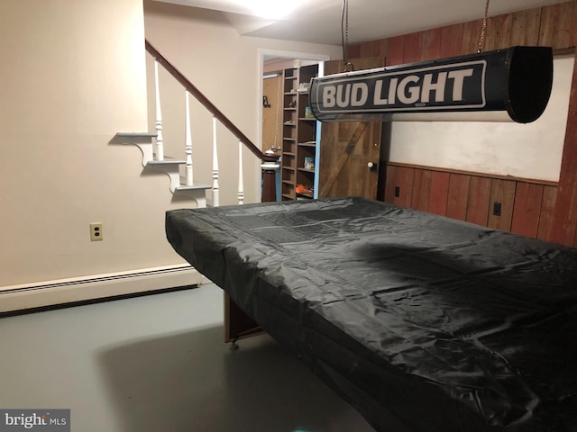 game room with concrete flooring, a baseboard radiator, pool table, and wooden walls