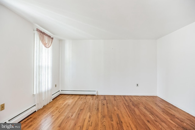 empty room with light wood-type flooring and baseboard heating