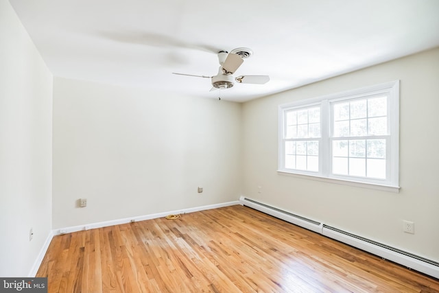 empty room with ceiling fan, light wood-type flooring, and a baseboard heating unit