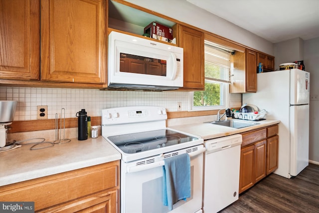 kitchen featuring white appliances, dark wood-type flooring, and sink