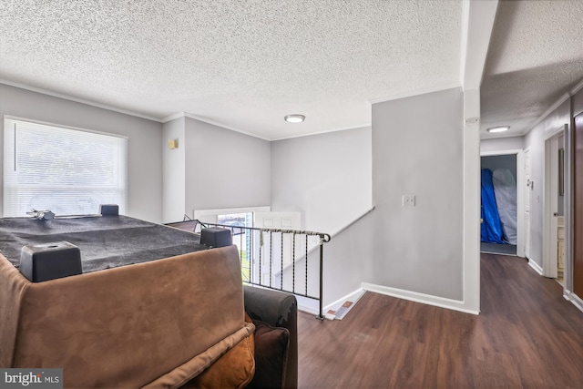 bedroom with crown molding, dark hardwood / wood-style flooring, and a textured ceiling