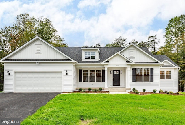 view of front of home featuring a front yard, driveway, a shingled roof, a garage, and board and batten siding