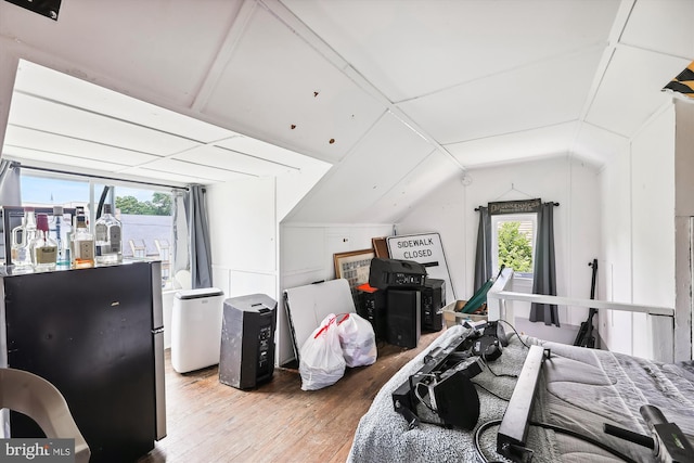 bedroom with lofted ceiling and wood-type flooring