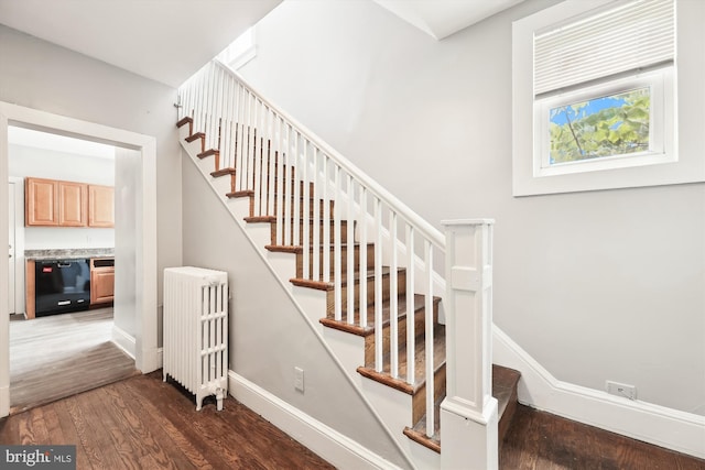 stairs with radiator and hardwood / wood-style flooring