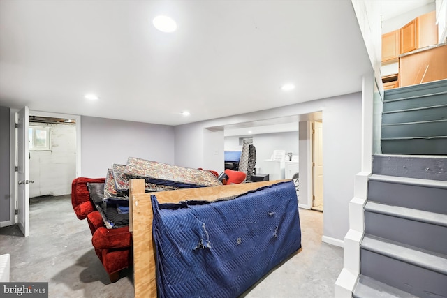 bedroom with independent washer and dryer and concrete floors