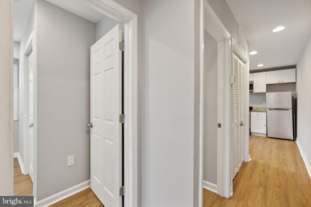 hallway with light hardwood / wood-style floors