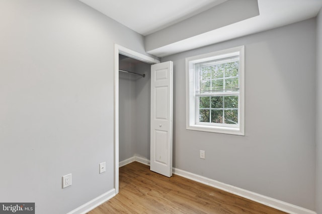 unfurnished bedroom with light hardwood / wood-style floors and a closet