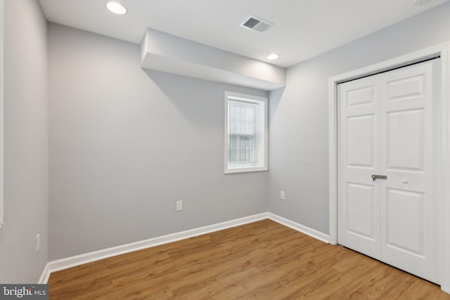 unfurnished bedroom with light hardwood / wood-style flooring and a closet