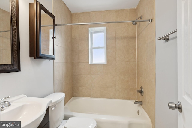 full bathroom with tiled shower / bath, toilet, and sink