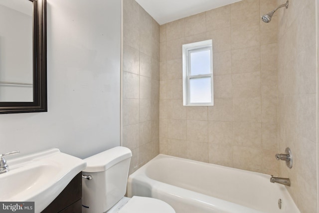 full bathroom featuring tiled shower / bath combo, vanity, and toilet