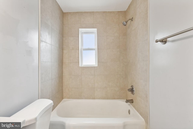 bathroom with toilet and tiled shower / bath combo