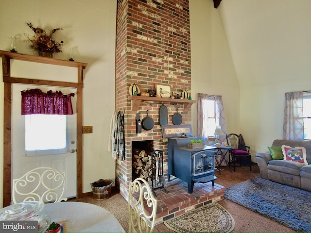 carpeted living room with a wood stove and high vaulted ceiling