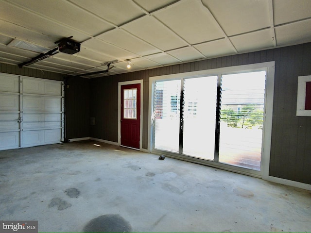 garage featuring wooden walls and a garage door opener