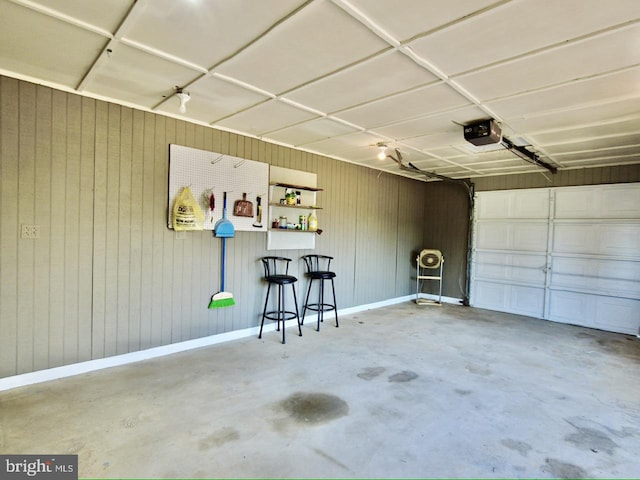 garage with wooden walls and a garage door opener