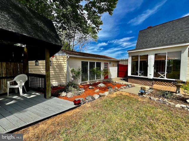 rear view of house featuring a lawn and a wooden deck