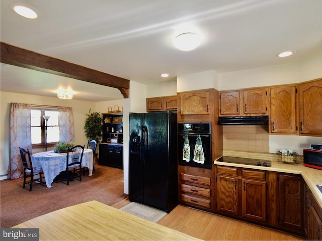 kitchen featuring light hardwood / wood-style floors, tasteful backsplash, and black appliances