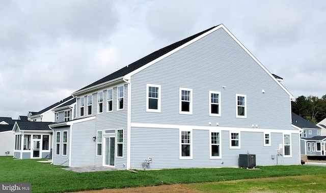 back of house with central AC unit, a patio area, and a yard