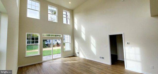 interior space with light hardwood / wood-style flooring and a high ceiling