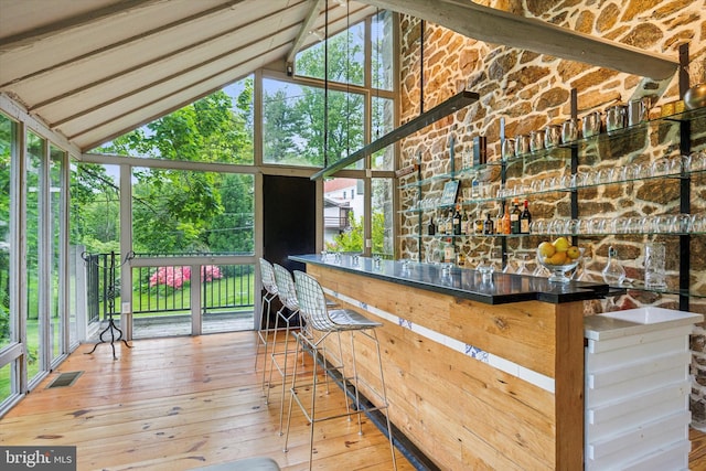 exterior space featuring beam ceiling, hardwood / wood-style flooring, and high vaulted ceiling