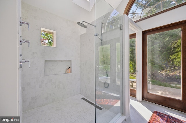 bathroom featuring a tile shower and a healthy amount of sunlight