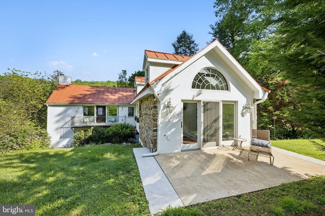 rear view of property with a lawn and a patio