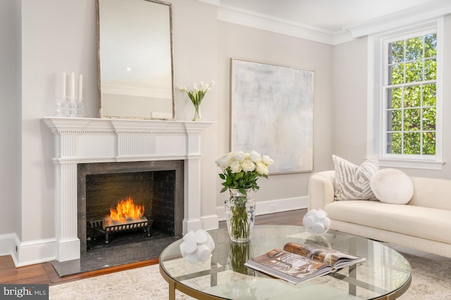 sitting room with hardwood / wood-style floors and crown molding