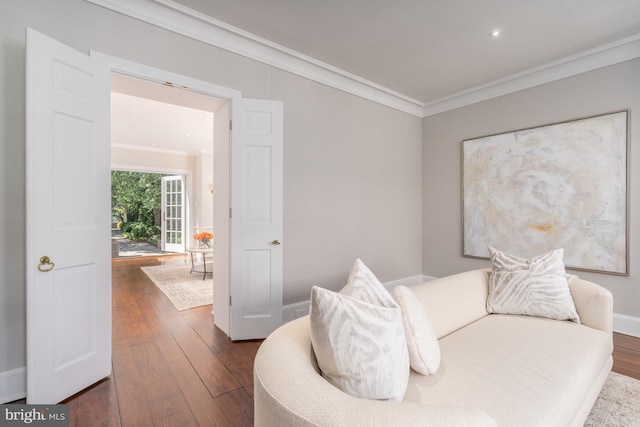 living area with crown molding and dark hardwood / wood-style flooring