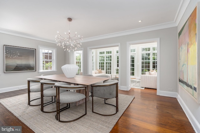 dining space featuring dark hardwood / wood-style flooring, ornamental molding, and a chandelier