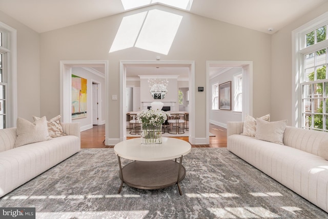 living room featuring wood-type flooring and lofted ceiling with skylight