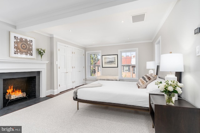 bedroom featuring beamed ceiling, crown molding, dark wood-type flooring, and a closet