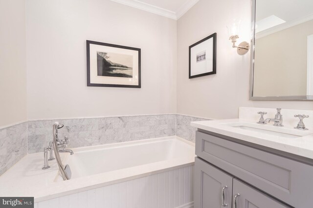 bathroom featuring vanity, ornamental molding, and a tub