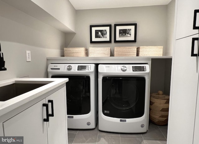 laundry room with cabinets, washing machine and dryer, and light tile patterned floors