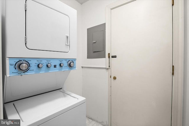 clothes washing area with stacked washer and dryer and electric panel