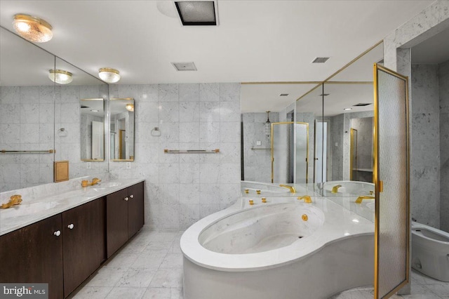 bathroom featuring a bathing tub, a bidet, vanity, and tile walls