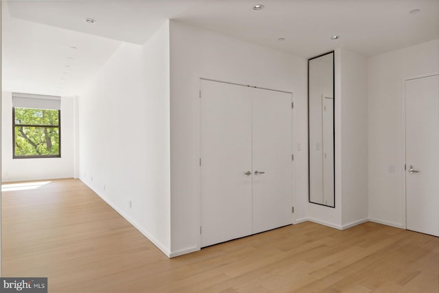 unfurnished bedroom with light wood-type flooring, baseboards, a closet, and recessed lighting