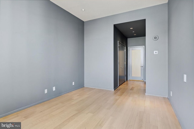 unfurnished room with light wood-type flooring and baseboards